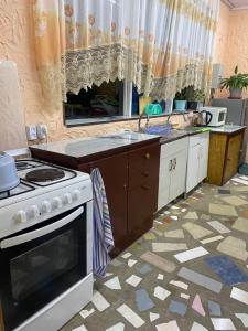 a kitchen with a stove and a counter top at уют in Cholpon-Ata