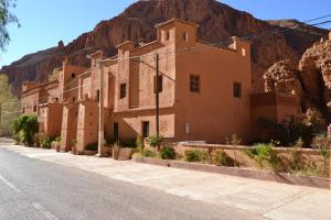 a building on the side of a street with a mountain at Auberge Tissadrine in Akhendachou nʼAït Ouffi