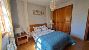 a bedroom with a bed with a blue blanket at Chez tatie Jacqueline in Albi