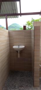 a bathroom with a sink in a wooden wall at Bilva Garden Penida in Polilit