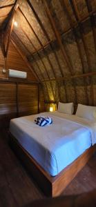 a bedroom with a large bed in a wooden ceiling at Bilva Garden Penida in Polilit