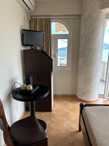 a room with a table and a chair and a tv at Palatino in Loutra Edipsou