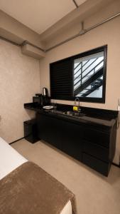 a bedroom with a sink and a large window at ADD Hóteis Congonhas in São Paulo