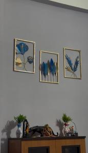 four pictures on the wall above a table at Triveni Stays in Jorhat +1 photo