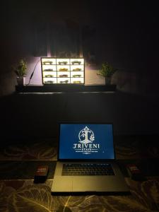 a laptop computer sitting on a bed in a dark room at Triveni Stays in Jorhat