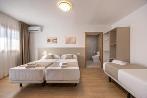 a bedroom with three beds and a bathroom at La Posada Boutique rooms Albir in Albir +66 photos