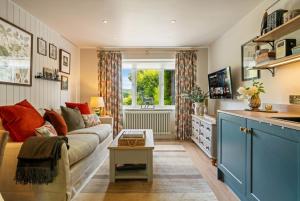 a living room with a couch and a table at Beautiful New Forest Hideaway in West Wellow