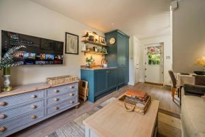 a living room with a blue cabinet and a table at Beautiful New Forest Hideaway in West Wellow