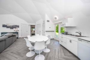 a white kitchen with a white table and chairs at Sumner Lake Tiny House in Clermont