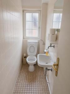 a white bathroom with a toilet and a sink at Hotel Ochsen in Leonberg
