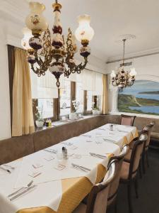 a dining room with a long table and a chandelier at Hotel Ochsen in Leonberg