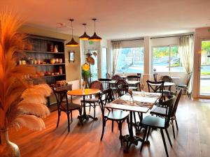 a restaurant with tables and chairs in a room at Hôtel Maisons Delphine - Le Cottage in Villers-sur-Mer