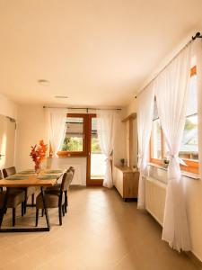 a dining room with a table and some windows at Apartma Arbores in Sveti Jurij ob Ščavnici