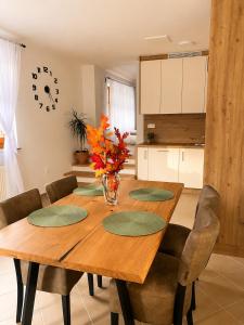 a dining room table with chairs and a vase of flowers on it at Apartma Arbores in Sveti Jurij ob Ščavnici