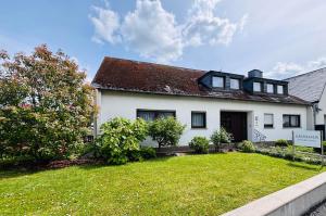 a white house with a grass yard at Gästehaus Am Rebenhang in Mehring