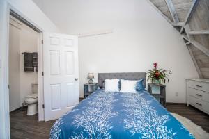 a bedroom with a blue bed and a toilet at ROOM 03 - Lake Sumner in Clermont