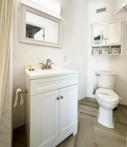 a white bathroom with a toilet and a sink at ROOM 04 - Lake Sumner in Clermont