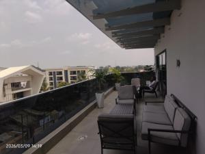 a balcony with chairs and a person sitting on it at Limeridge Signature Hotel in Ikeja