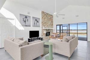 a living room with two couches and a television at SWISS 06 - Lake Sumner in Clermont
