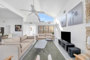 a living room with a couch and a tv at SWISS 06 - Lake Sumner in Clermont