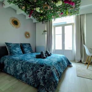 a bedroom with a blue bed with flowers on the ceiling at Urban Jungle Experience Hyper Centre Gare in Épinal