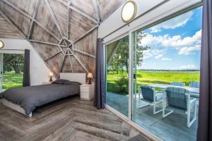 a bedroom with a bed and a large window at STUDIO 01 - Lake Sumner in Clermont
