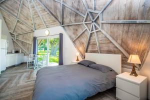 a bedroom with a large bed and a wooden wall at STUDIO 01 - Lake Sumner in Clermont