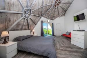 a bedroom with a large bed with a wooden ceiling at STUDIO 01 - Lake Sumner in Clermont