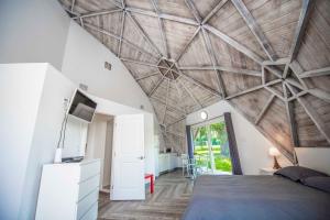 a bedroom with a wooden ceiling with a bed and a tv at STUDIO 01 - Lake Sumner in Clermont