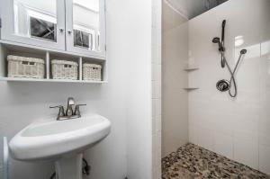 a white bathroom with a sink and a shower at STUDIO 01 - Lake Sumner in Clermont +6 photos