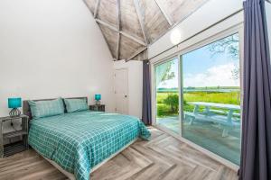 a bedroom with a bed and a large window at STUDIO 05 - Lake Sumner in Clermont +6 photos