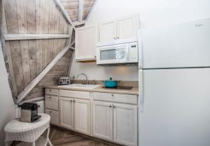 a kitchen with white cabinets and a white refrigerator at STUDIO 05 - Lake Sumner in Clermont