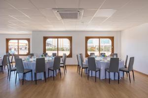 a conference room with tables and chairs and windows at La Posada Boutique rooms Albir in Albir