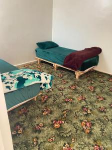 two beds sitting in a room with a carpet at Cozy Flat in Tan-Tan in Tan-Tan