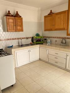 a kitchen with white cabinets and a white refrigerator at Cozy Flat in Tan-Tan in Tan-Tan