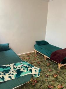 a room with two beds and a green mattress at Cozy Flat in Tan-Tan in Tan-Tan