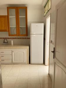 a kitchen with a white refrigerator in a room at Cozy Flat in Tan-Tan in Tan-Tan +2 photos
