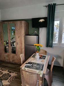 a kitchen with a table with chairs and a refrigerator at Liana's house 2 in Perama