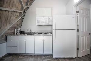 a white kitchen with a refrigerator and a microwave at STUDIO 02 - Lake Sumner in Clermont +8 photos