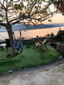 a hammock under a tree next to the water at Liana's house 2 in Perama