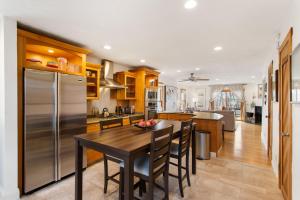 a kitchen with a wooden table and a stainless steel refrigerator at Bird's Nest -2BR Downtown Saugatuck Walkable in Saugatuck