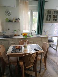a kitchen with a table with a vase of flowers on it at Liana's house 2 in Perama +15 photos