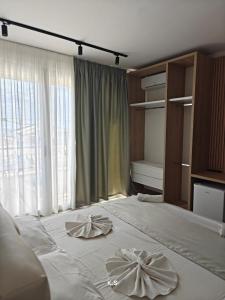 a bedroom with a bed with two napkins on it at SeaView Vacation Rooms in Durrës