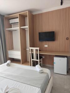 a bedroom with a bed and a desk and a tv at SeaView Vacation Rooms in Durrës +17 photos