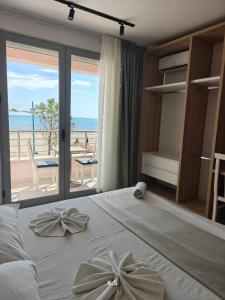a bedroom with a bed with a view of the beach at SeaView Vacation Rooms in Durrës