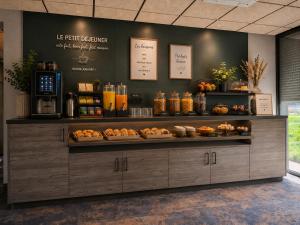 a bakery with a counter with food on it at APARTÉ HOTEL Dijon Sud in Chenôve