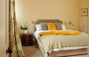 a bedroom with a bed with a yellow blanket at Number 6 Narrow Water Castle in Warrenpoint