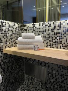 a bathroom with towels on a shelf with a mirror at Hotel Oliver in Bogotá +25 photos