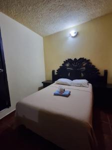 a bedroom with a bed with a blue tray on it at Hotel Posada Aurorita in Villahermosa