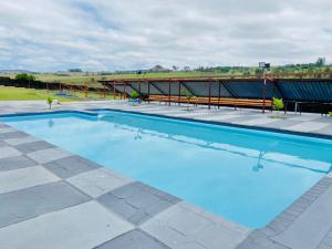 a large swimming pool with blue water at Mabutane Villas in Badplaas